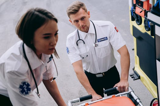 Two paramedics load a stretcher into an ambulance, ready for emergency response.